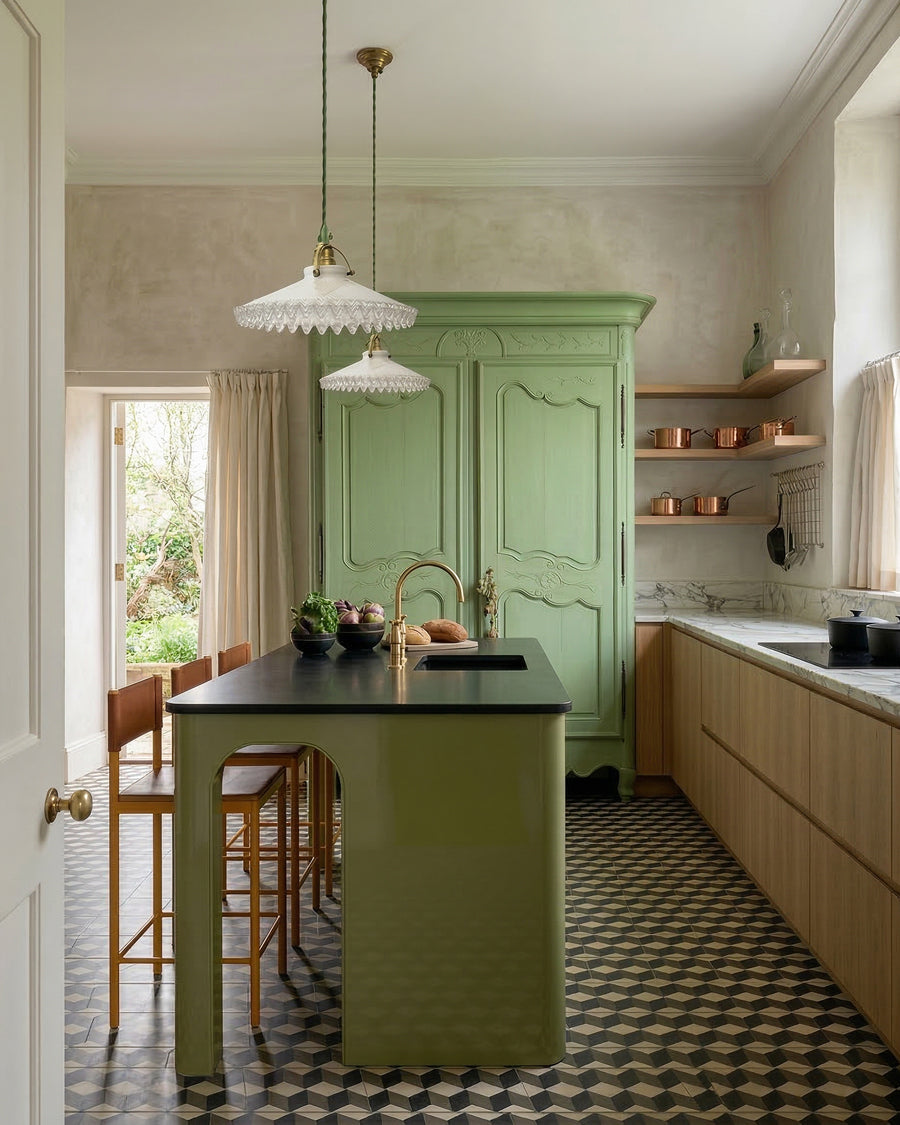Modern kitchen with a green island and classic French glass pendant lights. On the background a green French antique armoire, available via Wildschut Antiques.