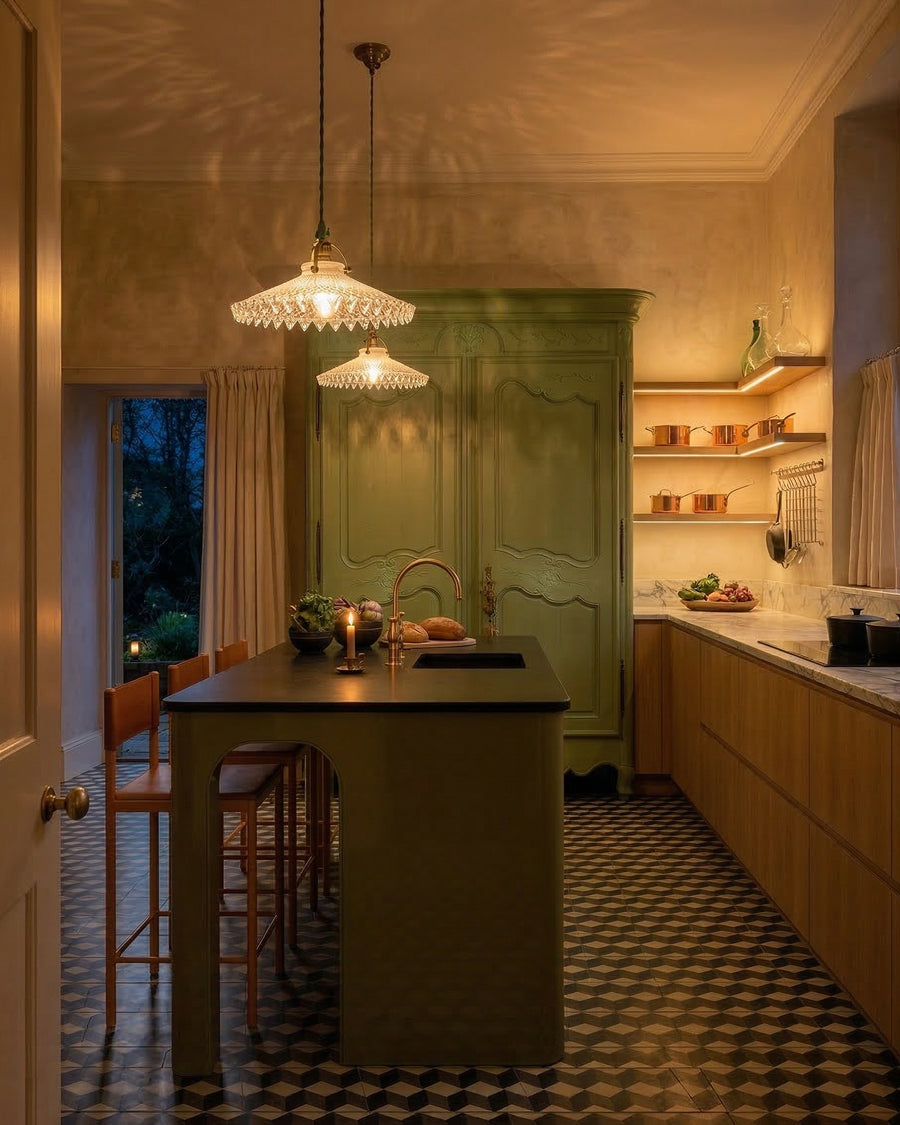Modern kitchen with a green island and classic French glass pendant lights. On the background a green French antique armoire, available via Wildschut Antiques.
