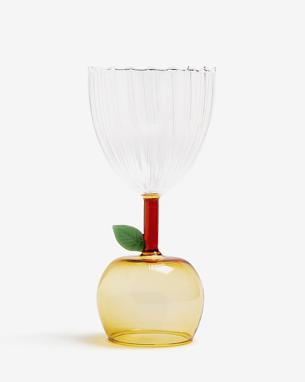 An apple-shaped wine glass with a clear body and a yellow base, featuring a single green leaf detail, part of Ichendorf Milano's Fruit and Flower collection