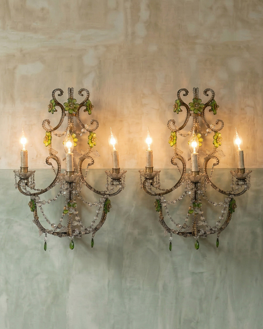 Pair of decorative wall sconces with candles on a textured wall, available via Wildschut Antiques