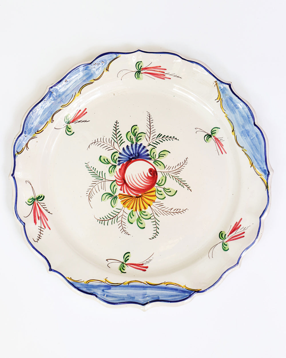 A large vintage hand-painted Italian ceramic plate with a floral design, predominantly white with blue and yellow accents along the rim