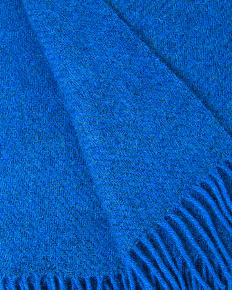 Close-up of a cobalt blue wool throw blanket with fringed edge by Klippan 1879, available at Wildschut Antiques.