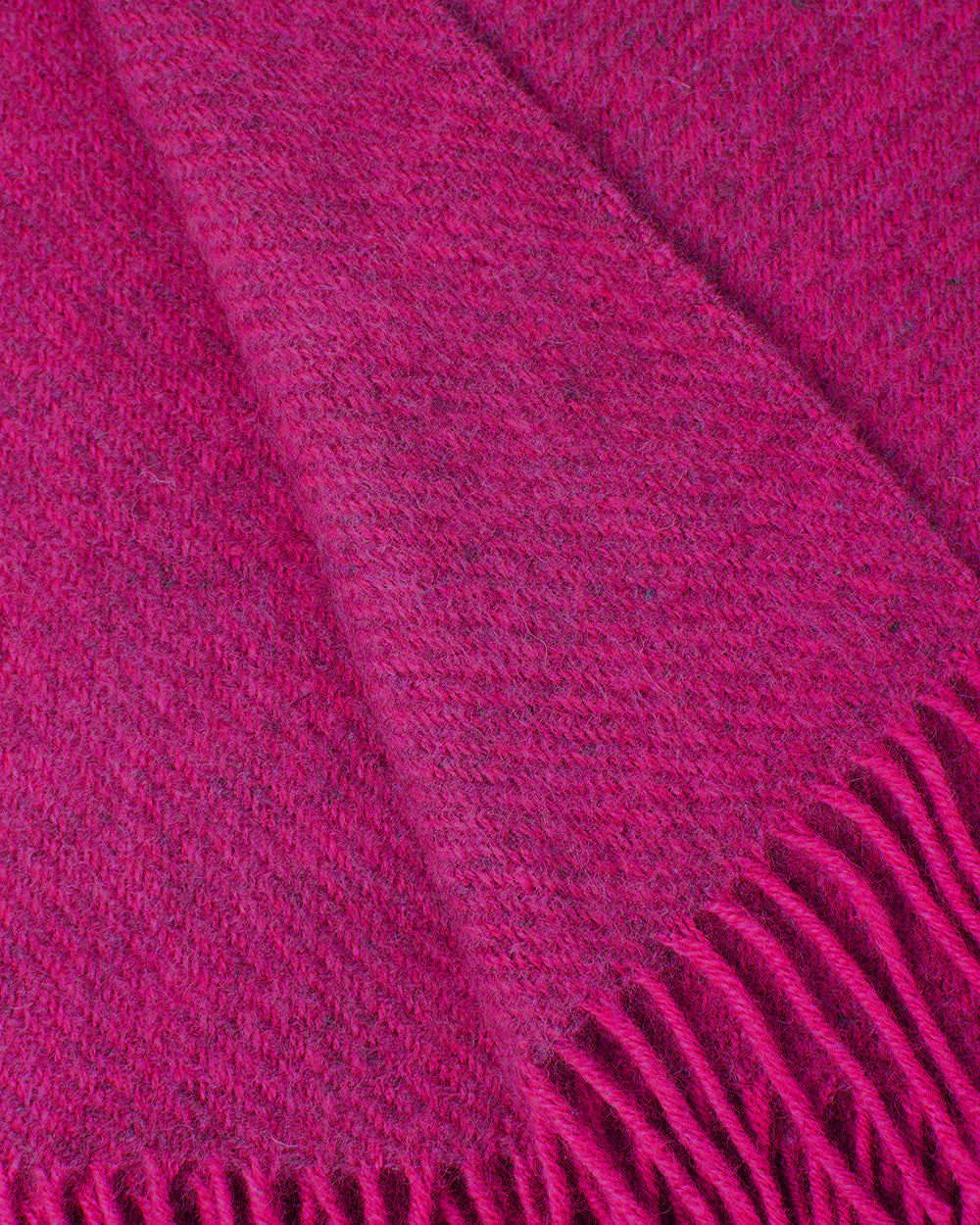 Close-up of a pink wool throw blanket with fringed edge by Klippan 1879, available at Wildschut Antiques.