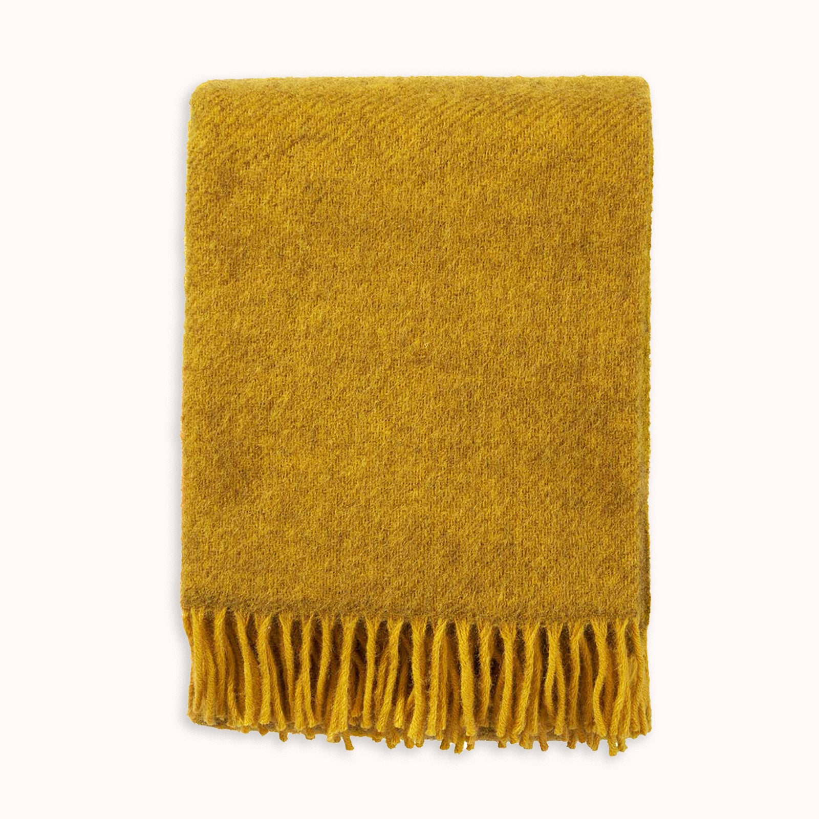 Mustard yellow wool throw blanket with fringes on a white background