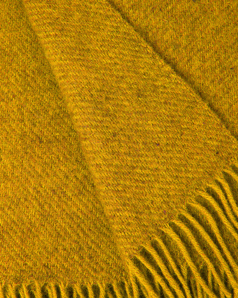Close-up of a honey yellow wool throw blanket with fringed edge by Klippan 1879, available at Wildschut Antiques.
