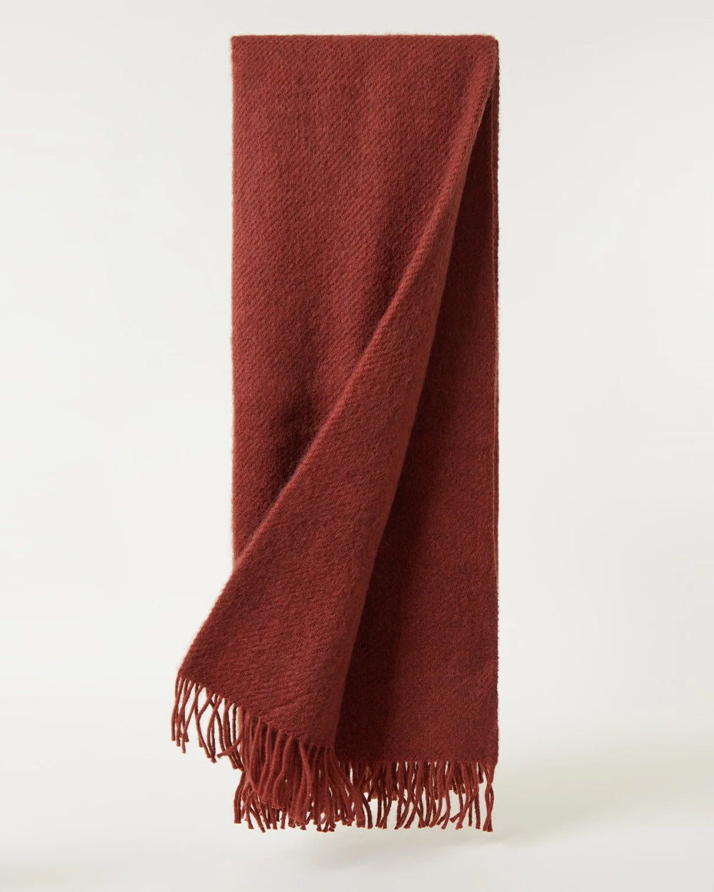 Rust red brown coloured blanket with fringes on a white background by Klippan 1879, available at Wildschut Antiques.