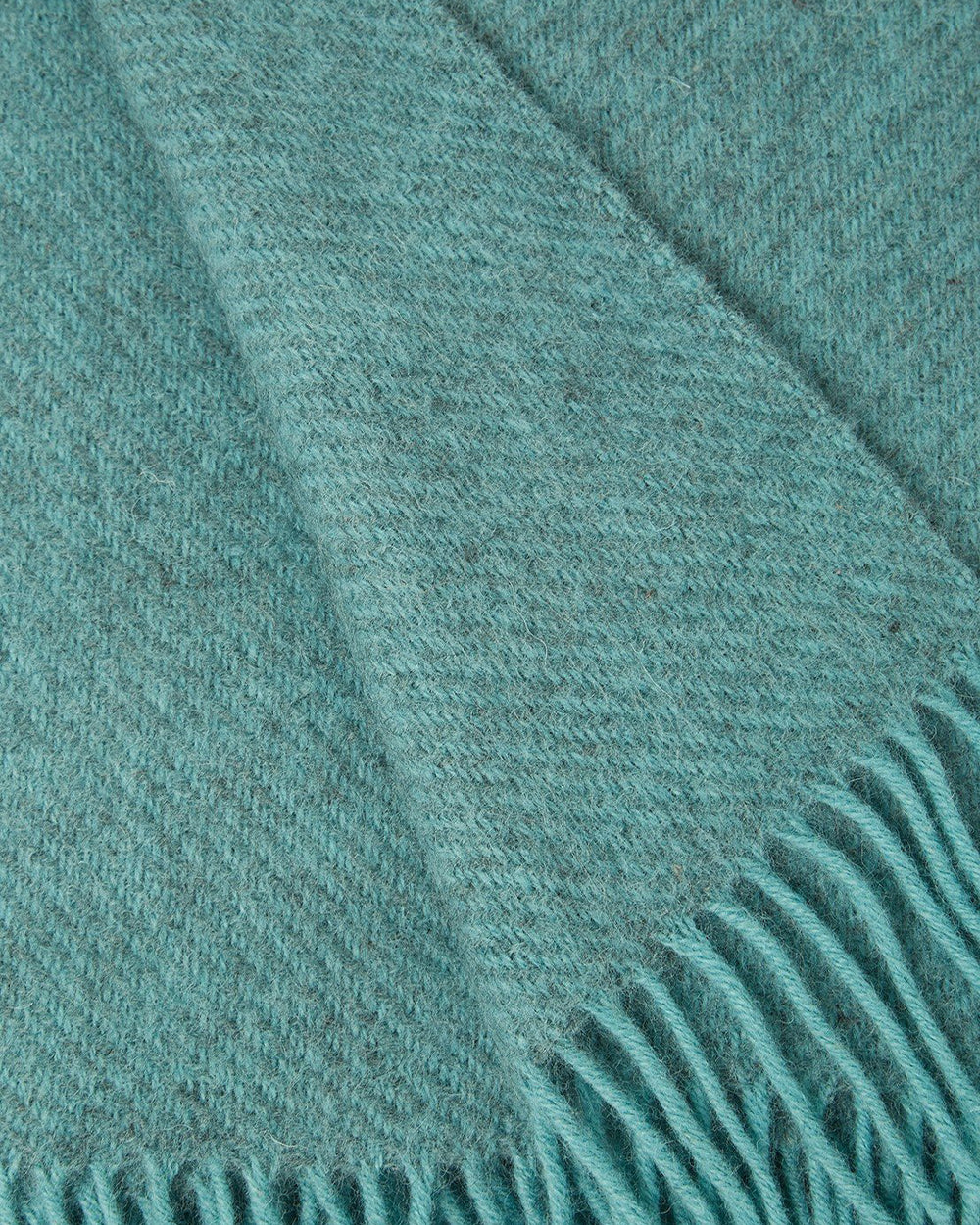 Close-up of a turquoise green blue wool throw blanket with fringed edge by Klippan 1879, available at Wildschut Antiques.