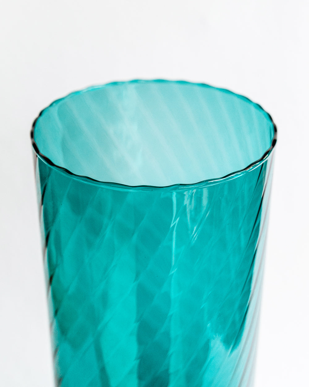 Close-up of a large vintage Murano glass vase in petrol blue with a swirl pattern