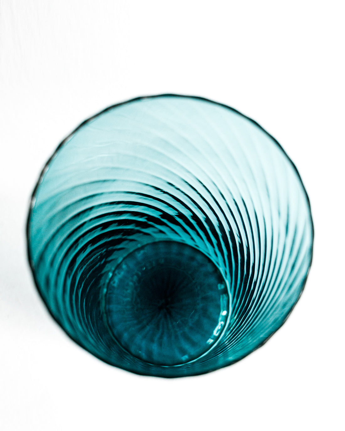 Close-up of a large vintage Murano glass vase in petrol blue with a swirl pattern