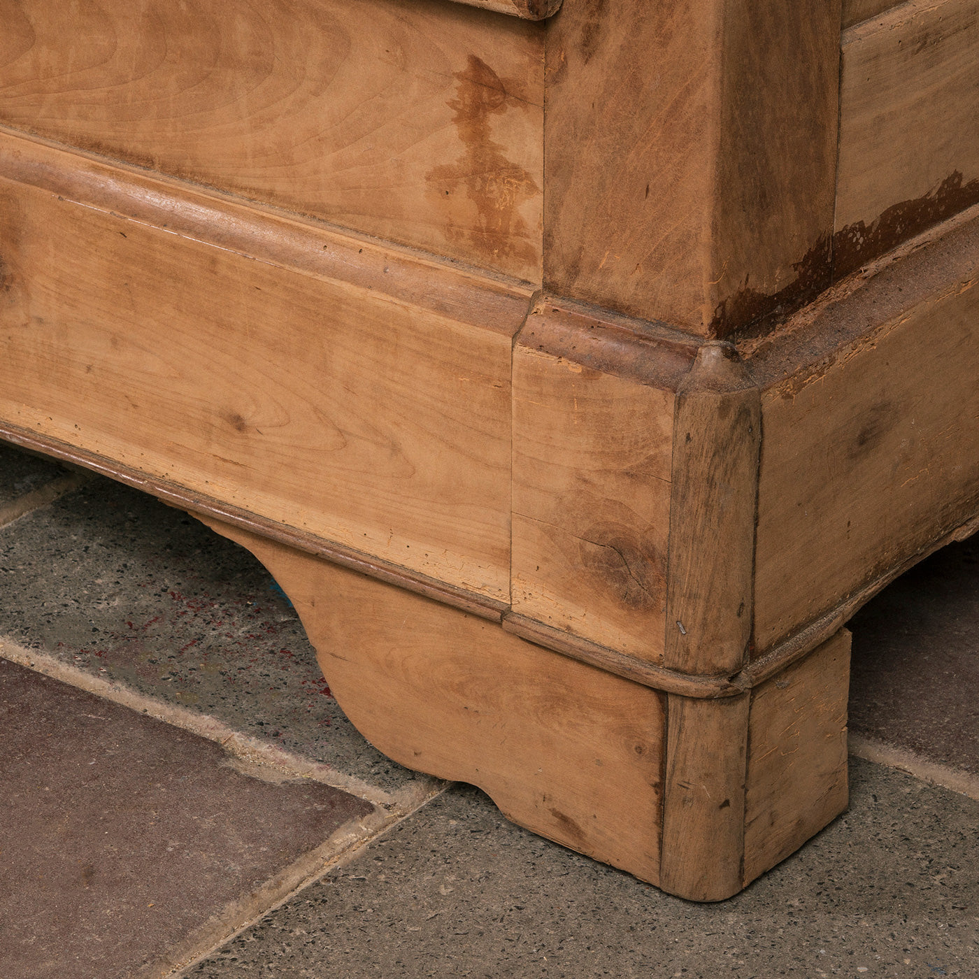 Close-up of a leg of an antique French Louis Philippe style armoire made from hand-sanded cherry wood