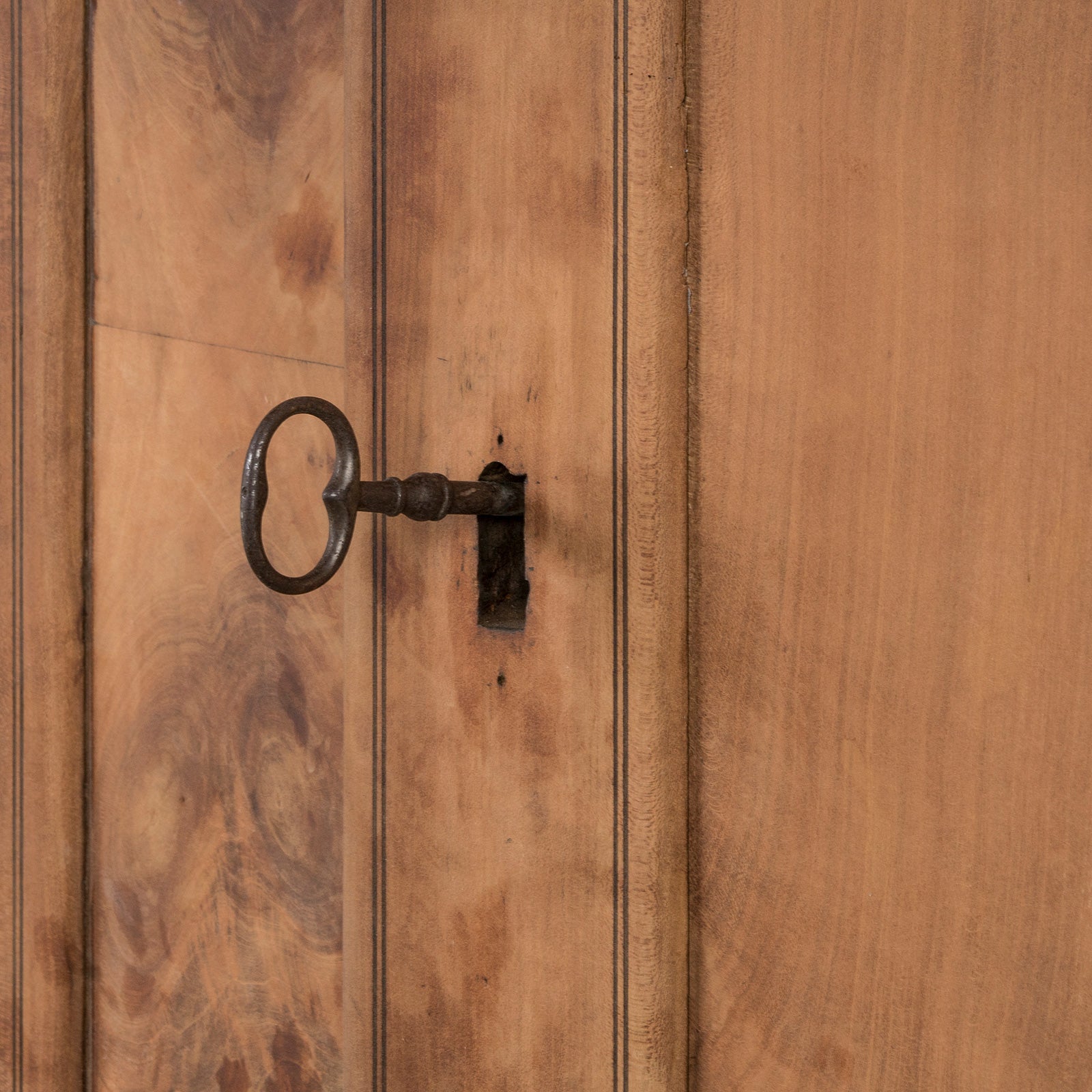 Close-up of the key of an antique French Louis Philippe style armoire made from hand-sanded cherry wood