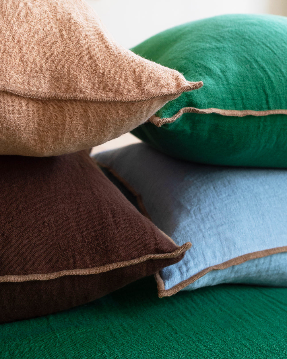 Close-up of a bunch of soft linen blend pillows with decorative seams available at Wildschut Antiques