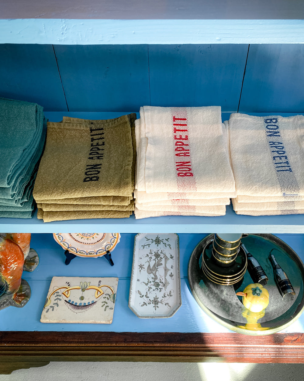Charvet Editions avocado green linen napkins and towels neatly folded at Wildschut Antiques boutique