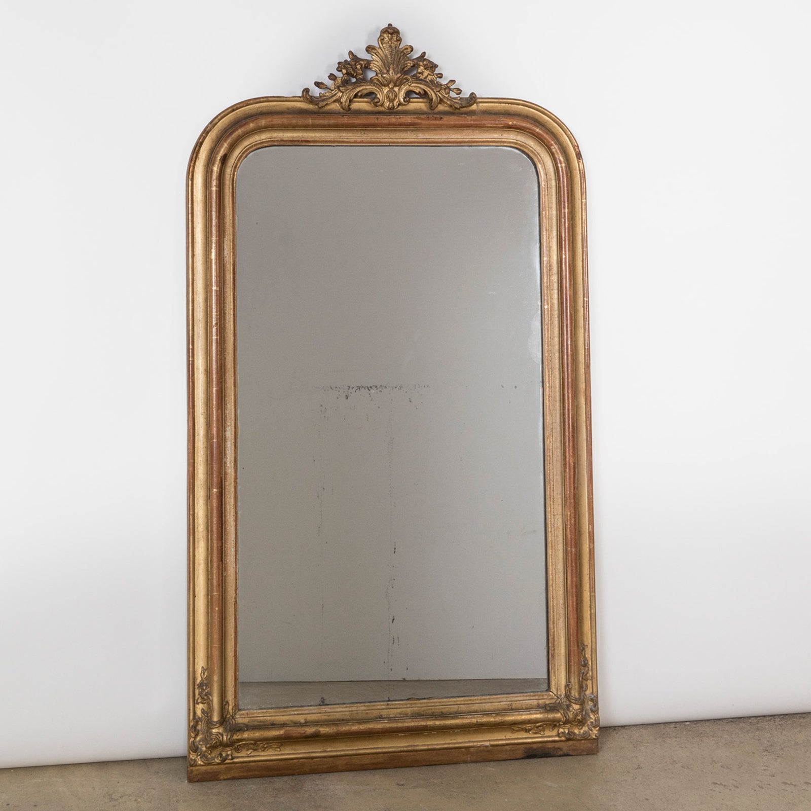 Antique French 19th Century Louis Philippe style gold gilt mirror with small crest and rounded upper corners and some foxing on the glass, available at Wildschut Antiques