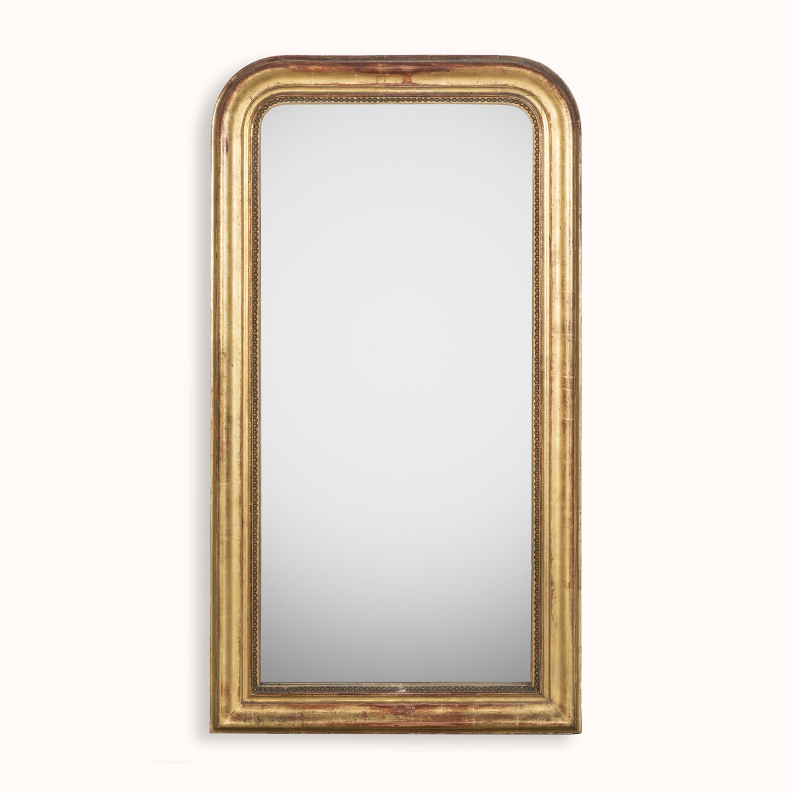 French antique Louis Philippe style mirror with a warm red glow