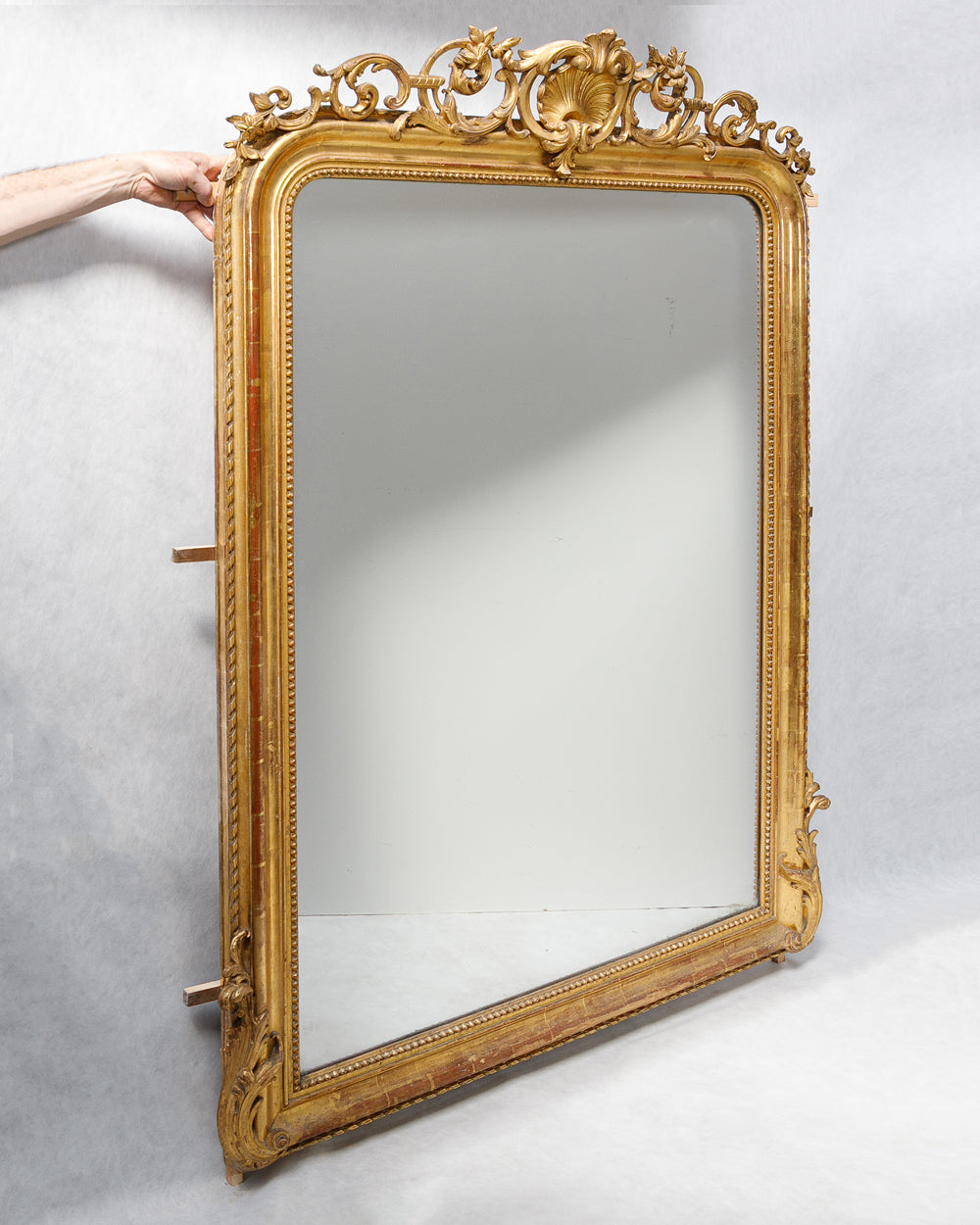Sideview of an antique French 19th Century Louis Philippe style gold gilt mirror with shell crest, leaf and flower ornaments, and pearl beading, available at Wildschut Antiques