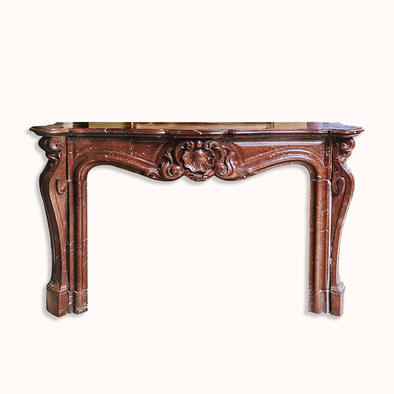 A grand antique French Rococo Louis XV fireplace mantel, crafted from richly veined red-brown marble, set against a clear background, available at Wildschut Antiques.