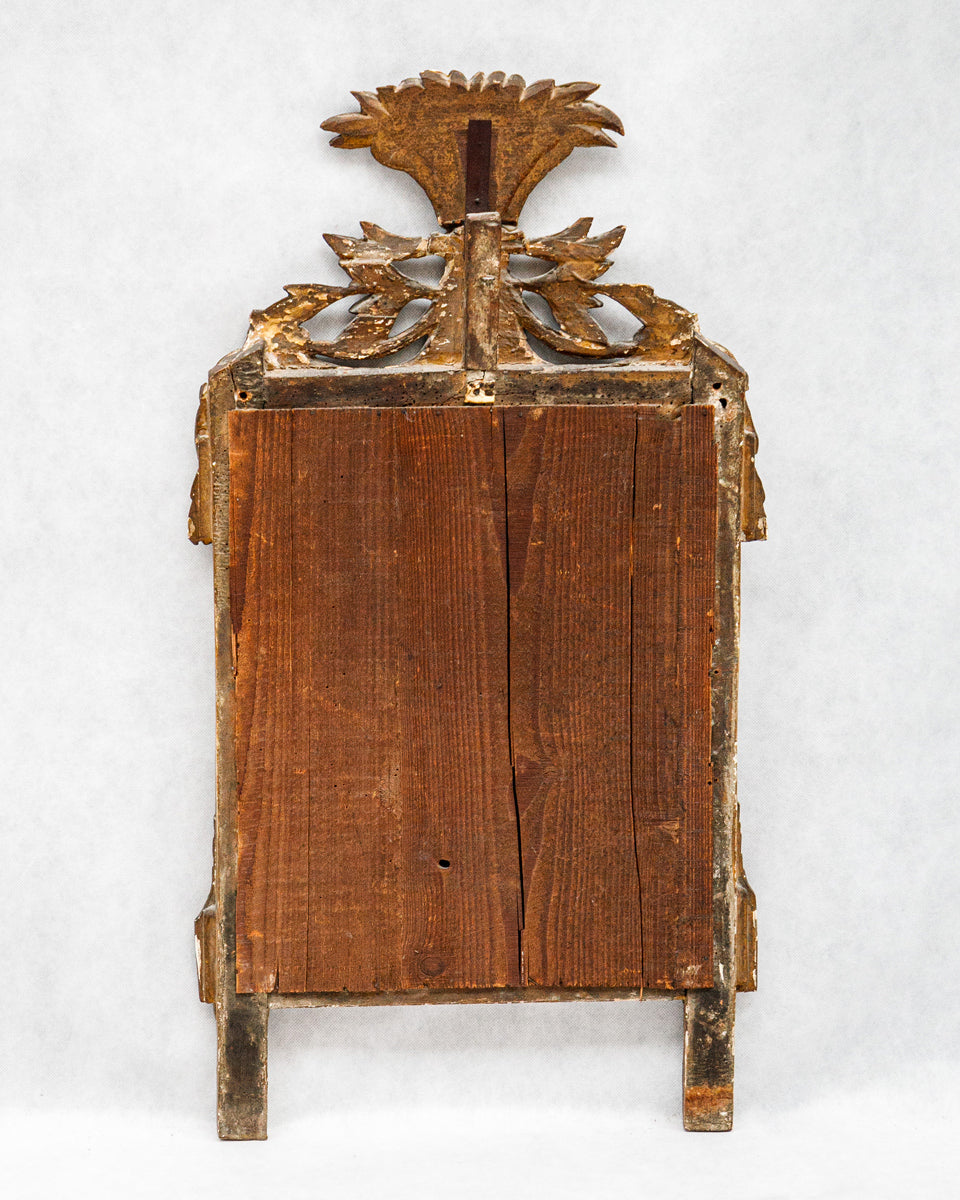 Wooden backside of a decorative antique French gold-framed marriage or wedding mirror with intricate design on a white background
