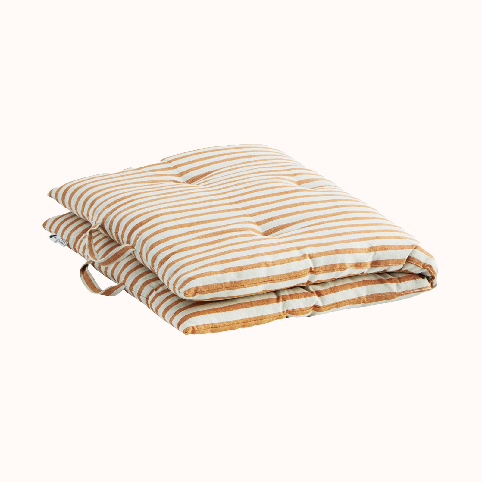 A folded rectangular cotton mattress with yellow and white stripes, displayed against a white background, available at Wildschut Antiques