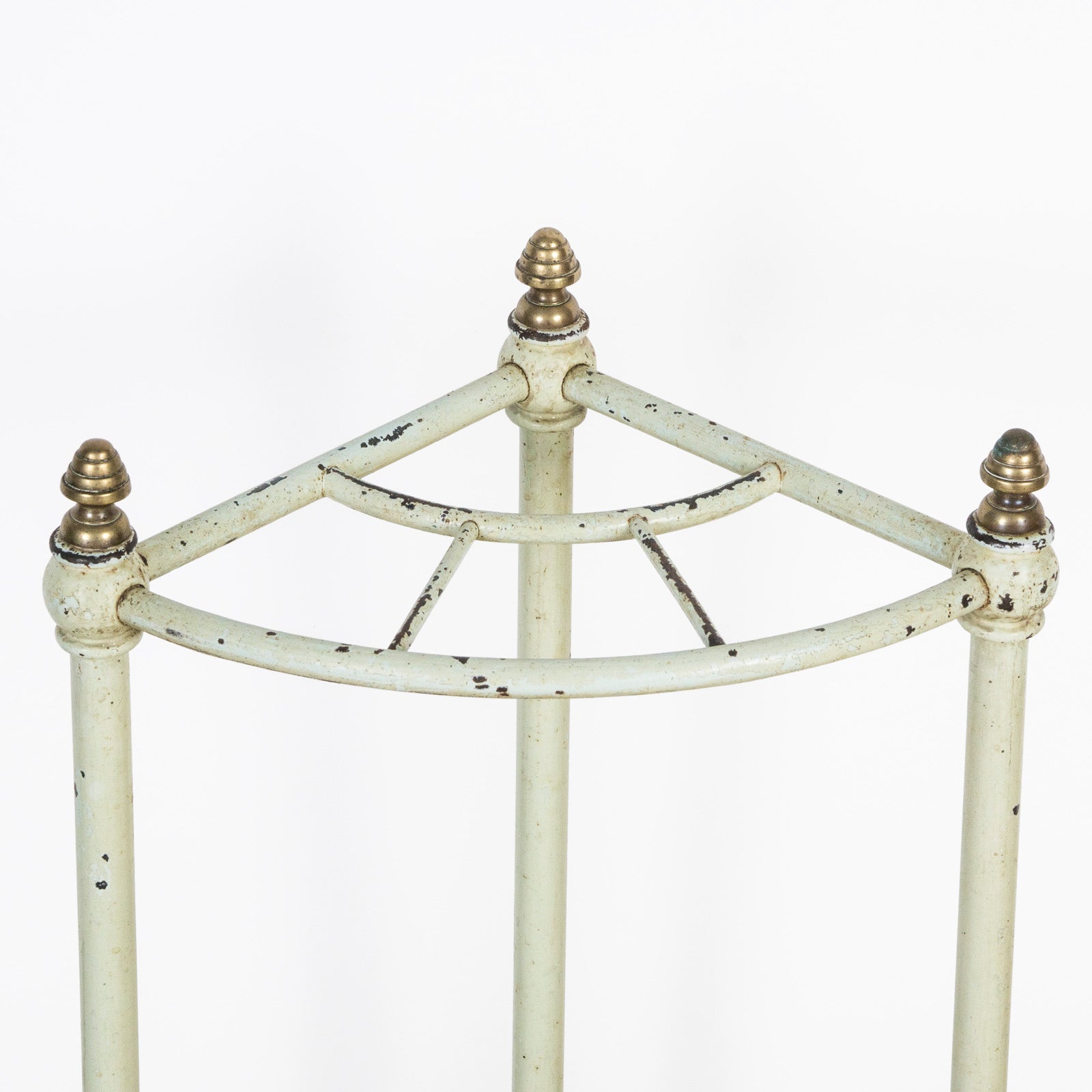 Close-up of the top part of an antique mint green brass and painted iron corner umbrella rack with four compartments, featuring a aged patina