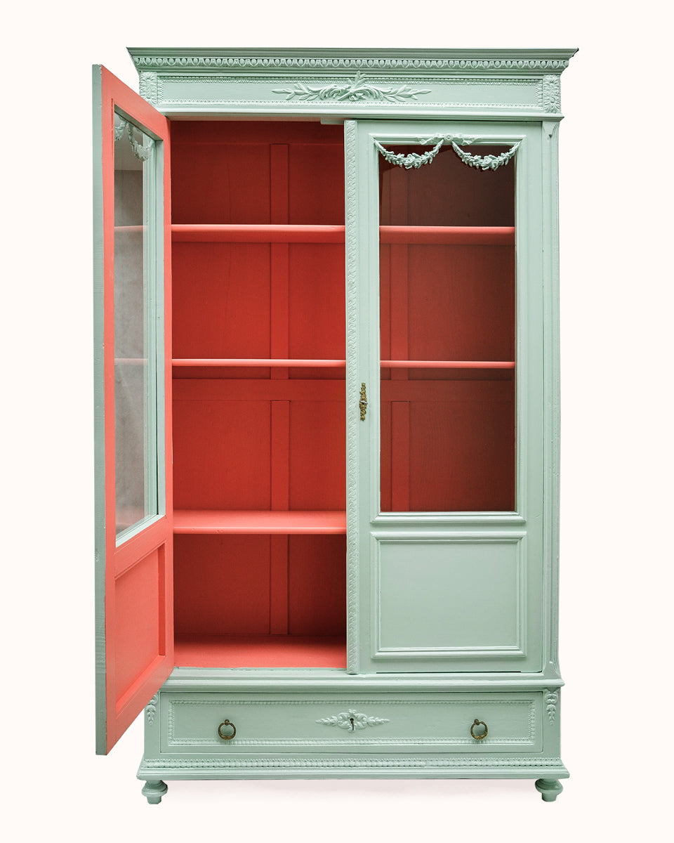 French Louis XVI-style vitrine cabinet with a soft mint green finish, glass doors, and contrasting red interior, shown with one door open, available at Wildschut Antiques
