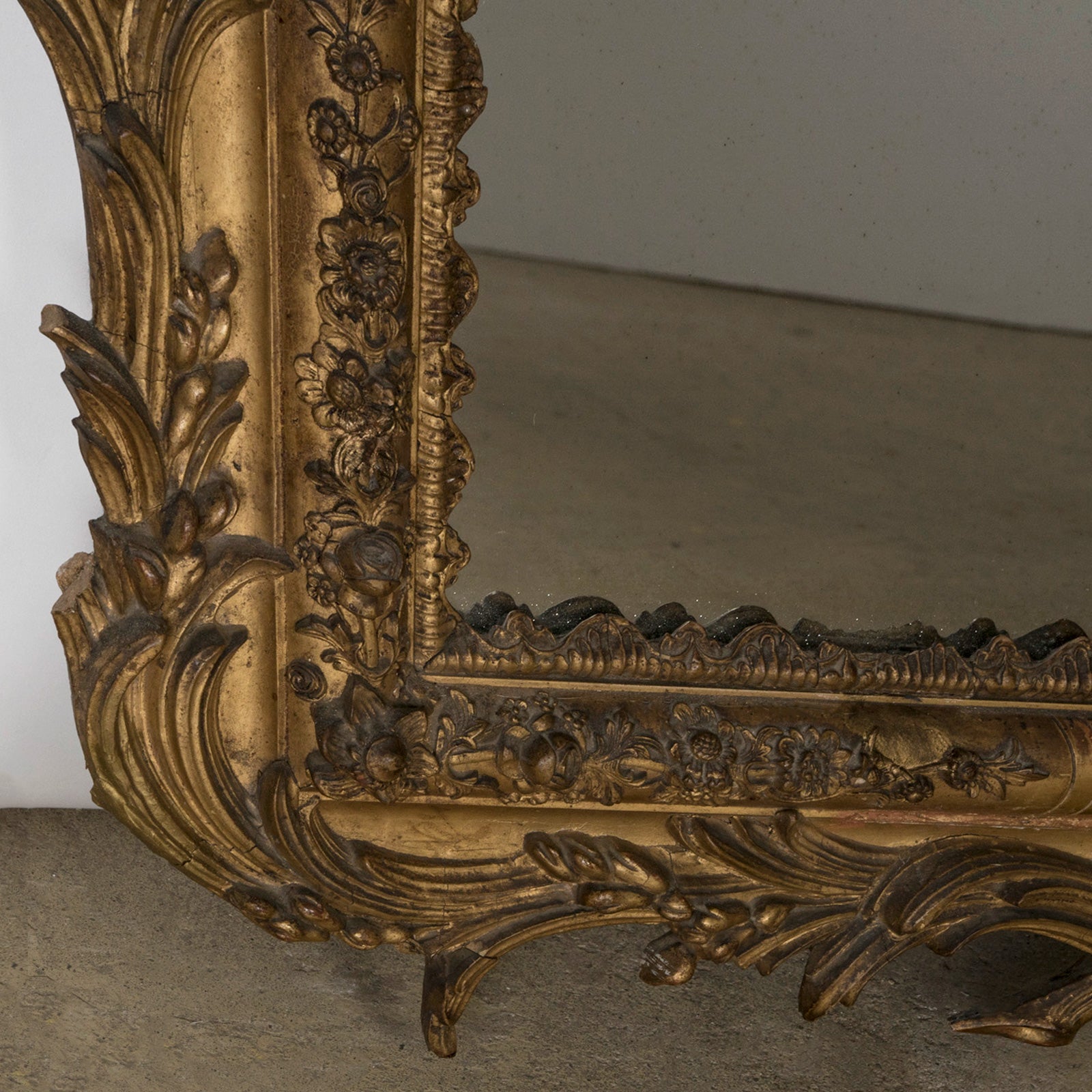 Close-up of an antique ornate Louis XV style provincal mirror with a gold carved frame