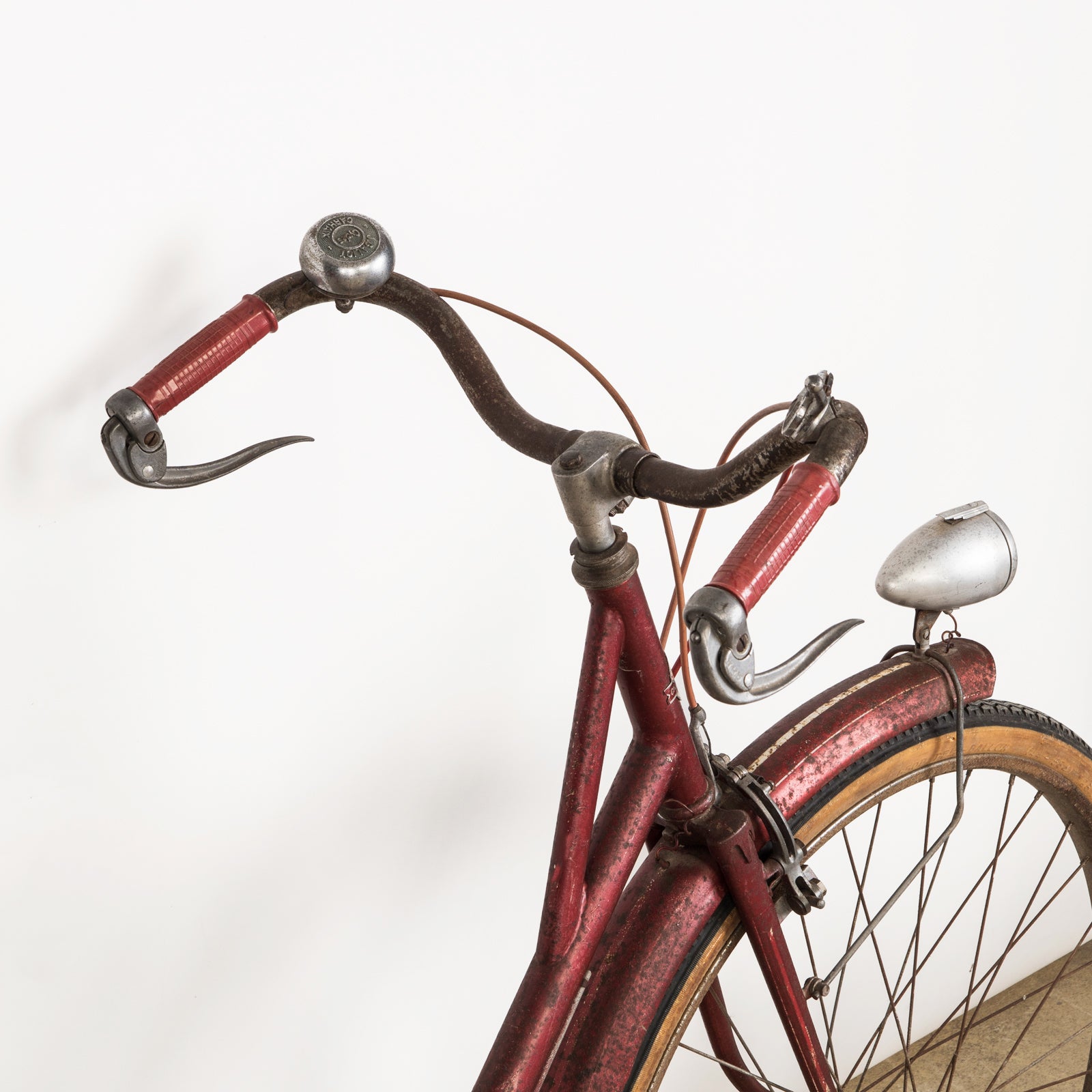 Close-up of the steer of a vintage French Mobylette motorcycle, type Mosquito, with a red body and red seat, featuring a great patina finish and original mechanisms