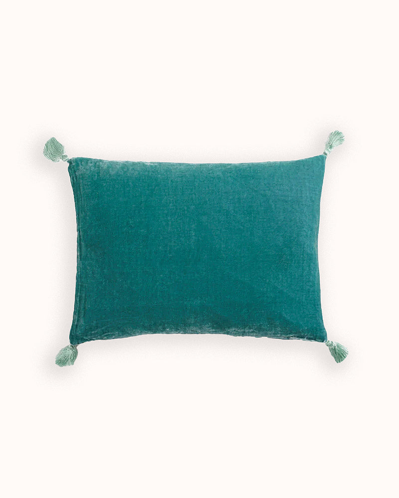 Turquoise velvet pillow with tassels on a light background, by Monde Sauvage available via Wildschut Antiques.