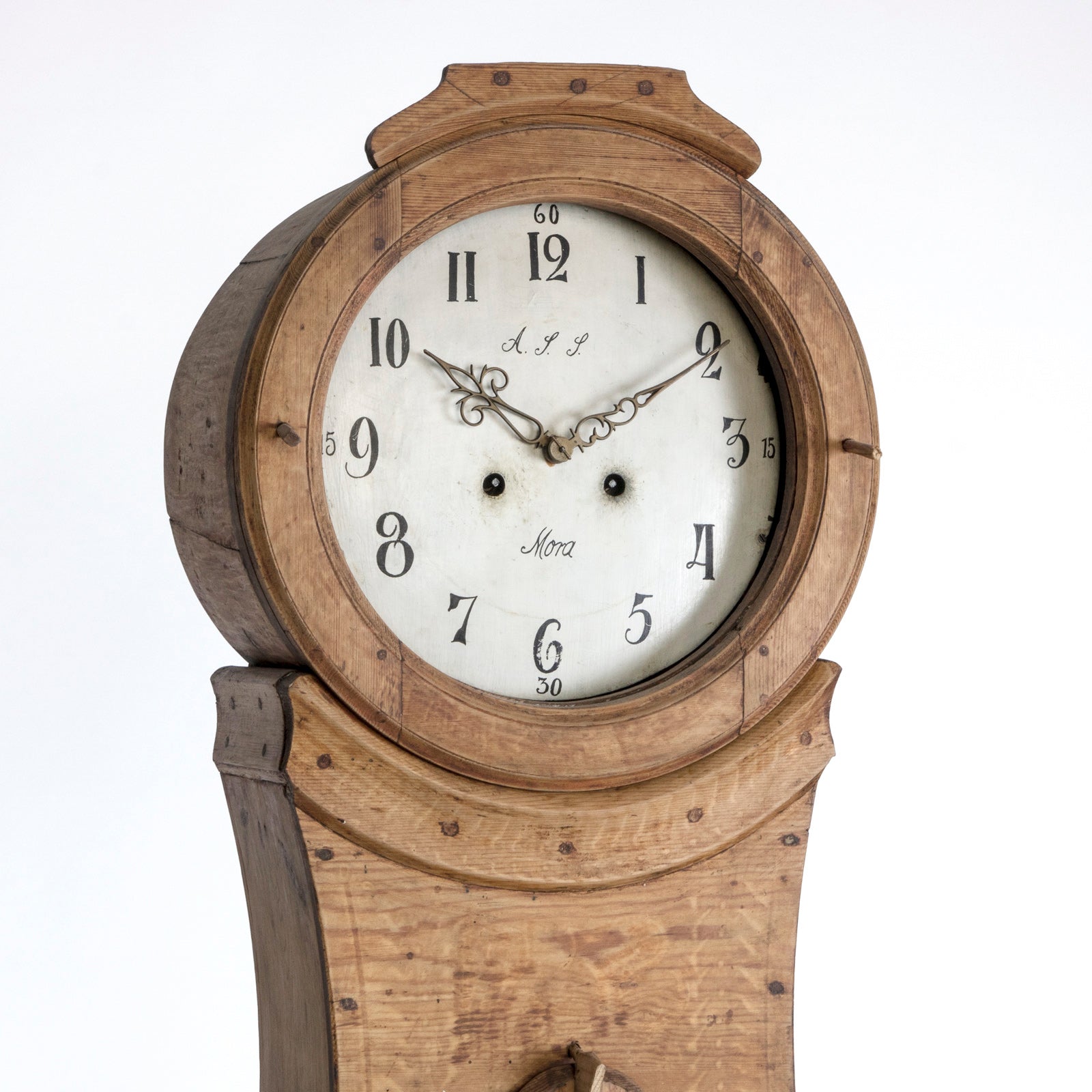 Close-up of an antique Swedish Mora clock with a natural finish, wide belly body, and a numeral face