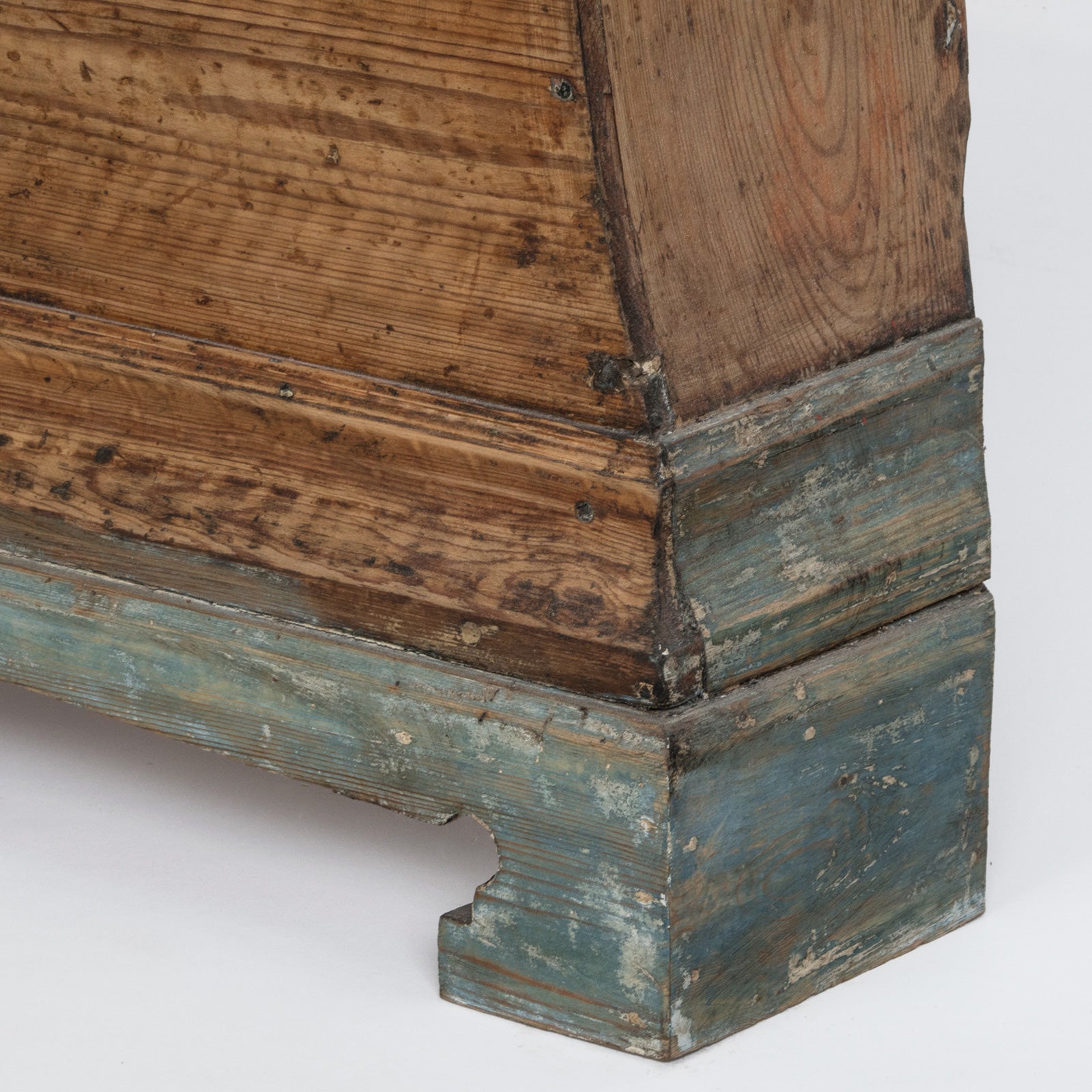 Close-up of the legs of an antique Swedish Mora clock with a natural finish, wide belly body, and a numeral face