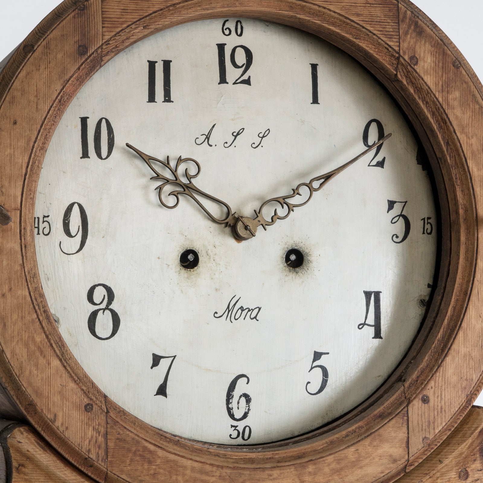 Close-up of an antique Swedish Mora clock with a natural finish, wide belly body, and a numeral face