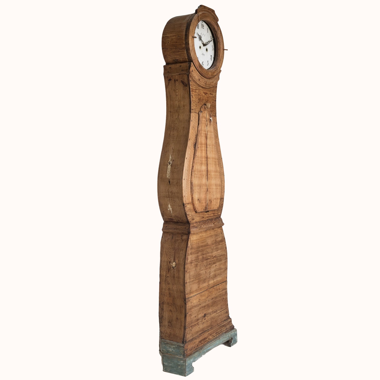 Side view of an antique Swedish Mora clock with a natural finish, wide belly body, and a numeral face