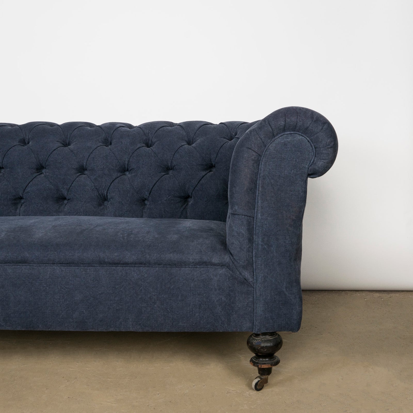 Close-up of an elegantly tufted 19th-century French Napoleon III sofa, upholstered in stonewashed blue linen—available at Wildschut Antiques.