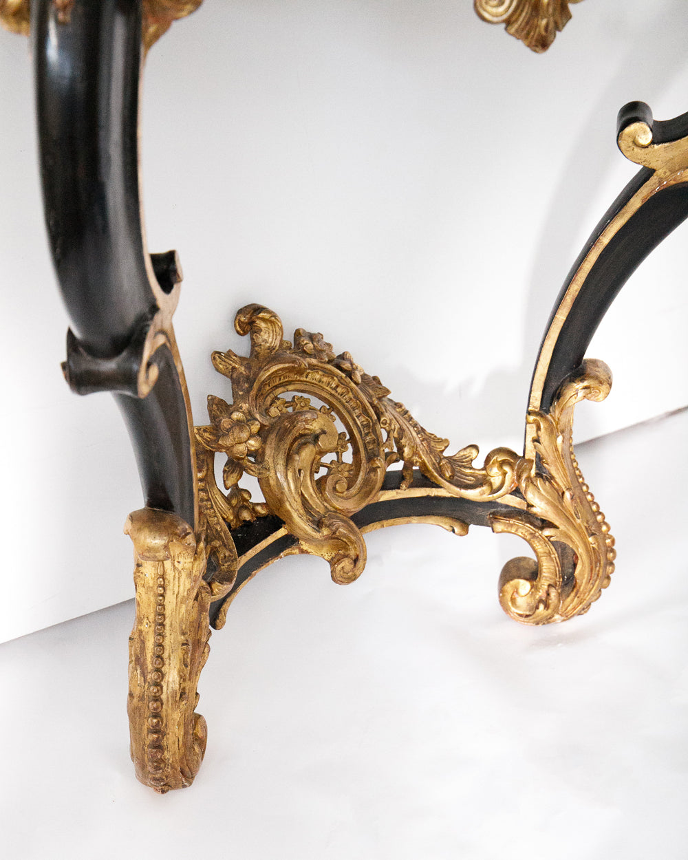 Detail of the legs of a very decorative antique Napoleon III style console table with gold and black embellishments available via Wildschut Antiques