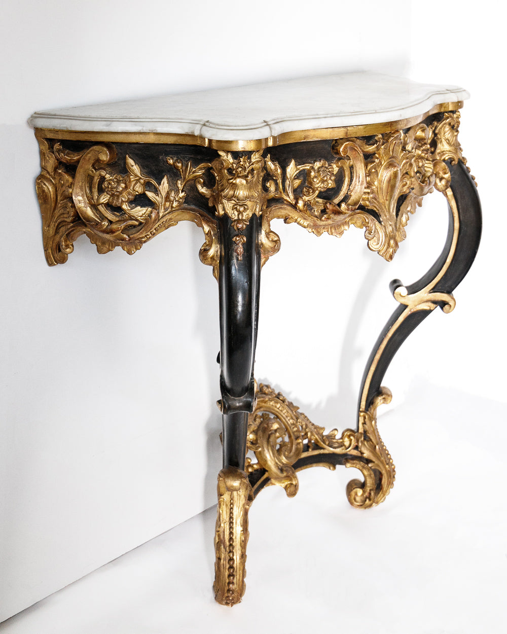 Decorative console table with gold and black intricate design and a marble top on a white background
