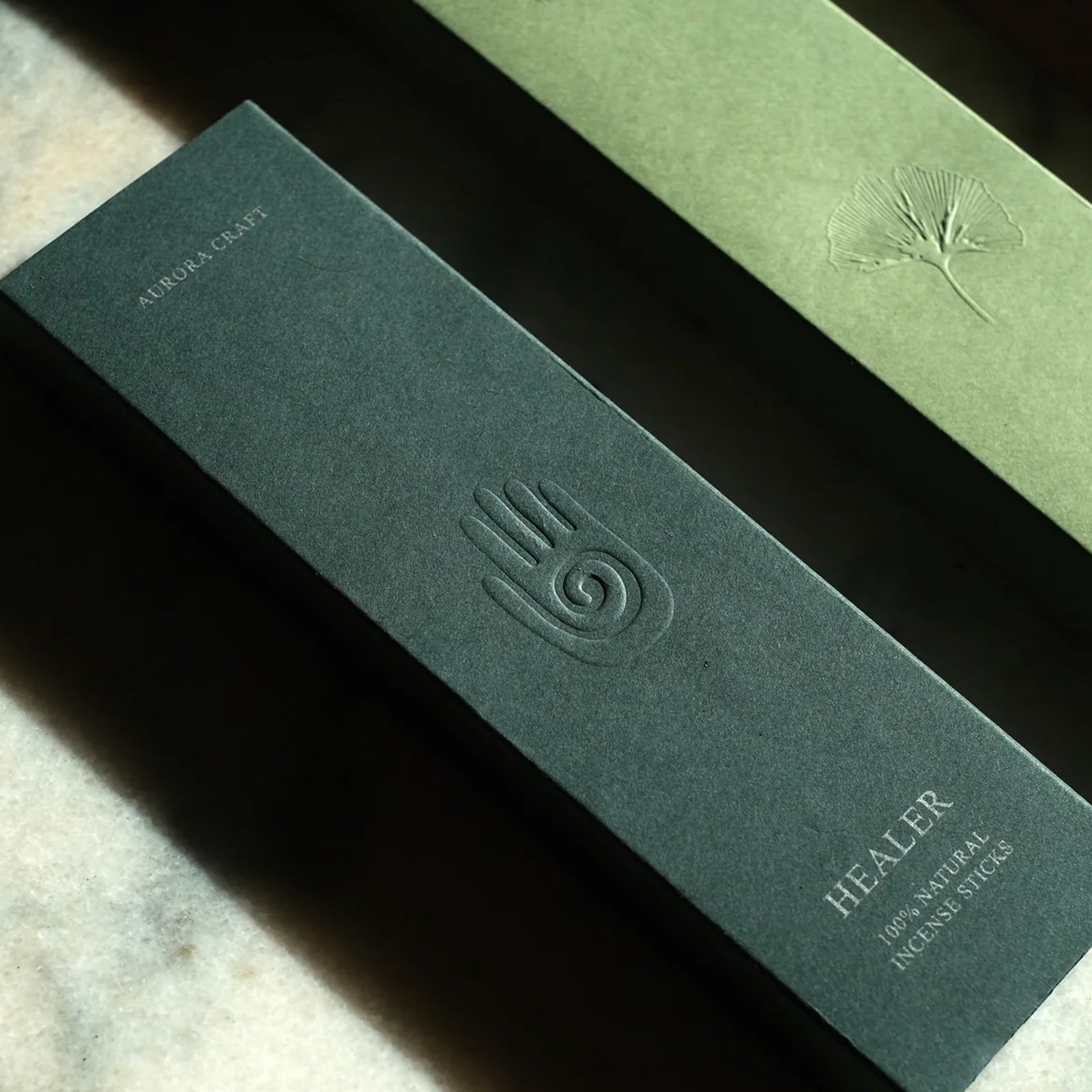 Two green boxes of natural incense branded by Aurora Craft