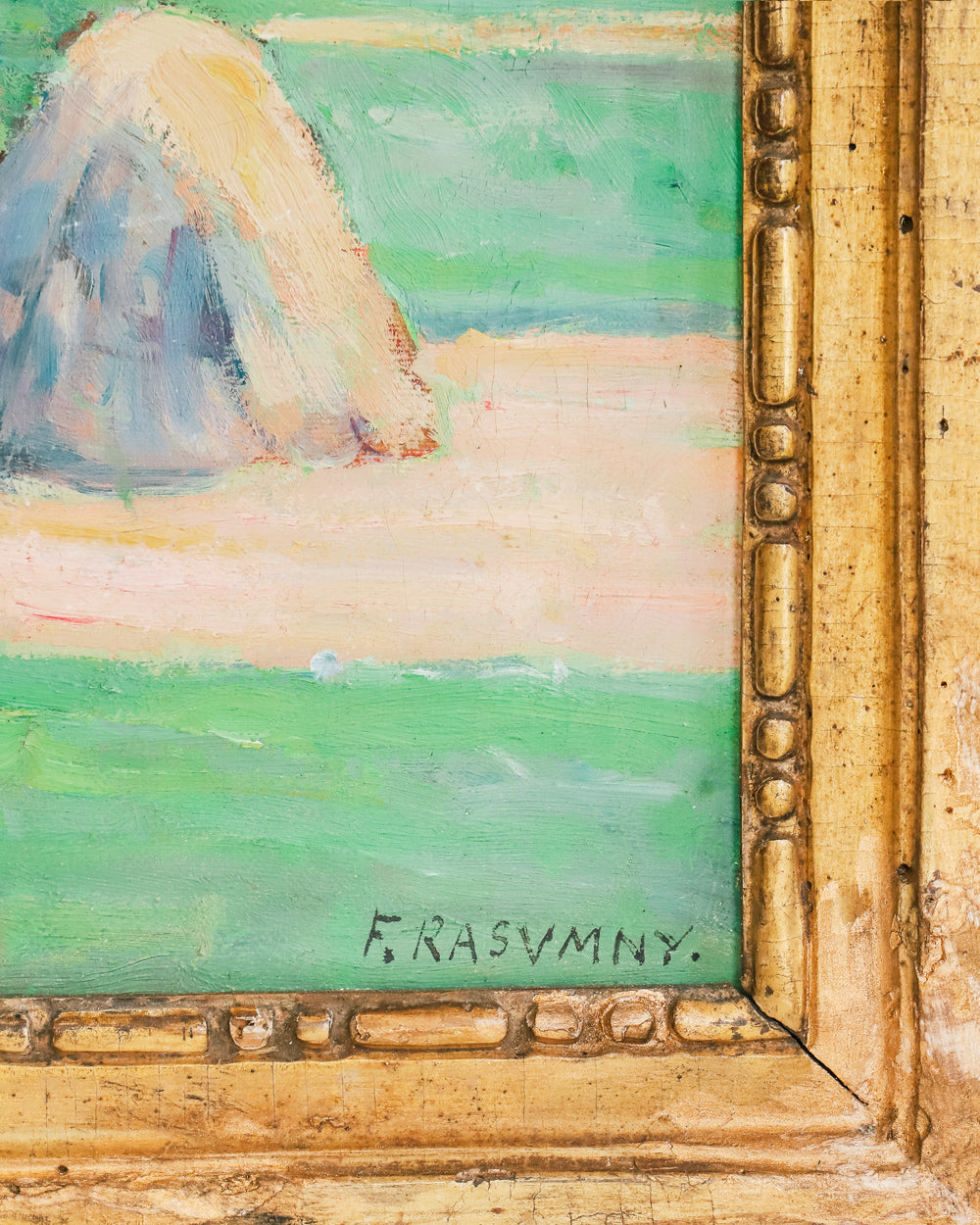 Close-up of a vibrant antique French painting showing a field with haystacks and distant figures at work, set in a giltwood frame, with the signature of the artist visible