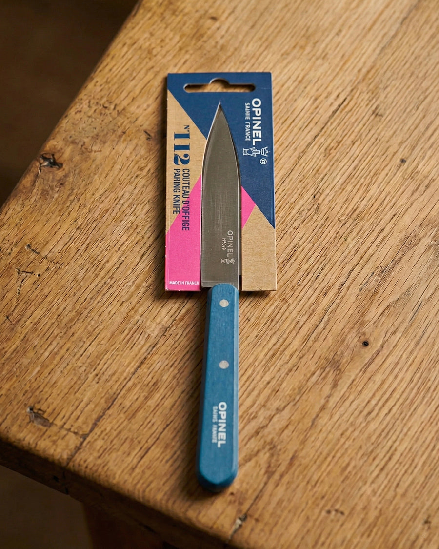 Opinel knife with blue handle and blade on a wooden surface, available via Wildschut Antiques