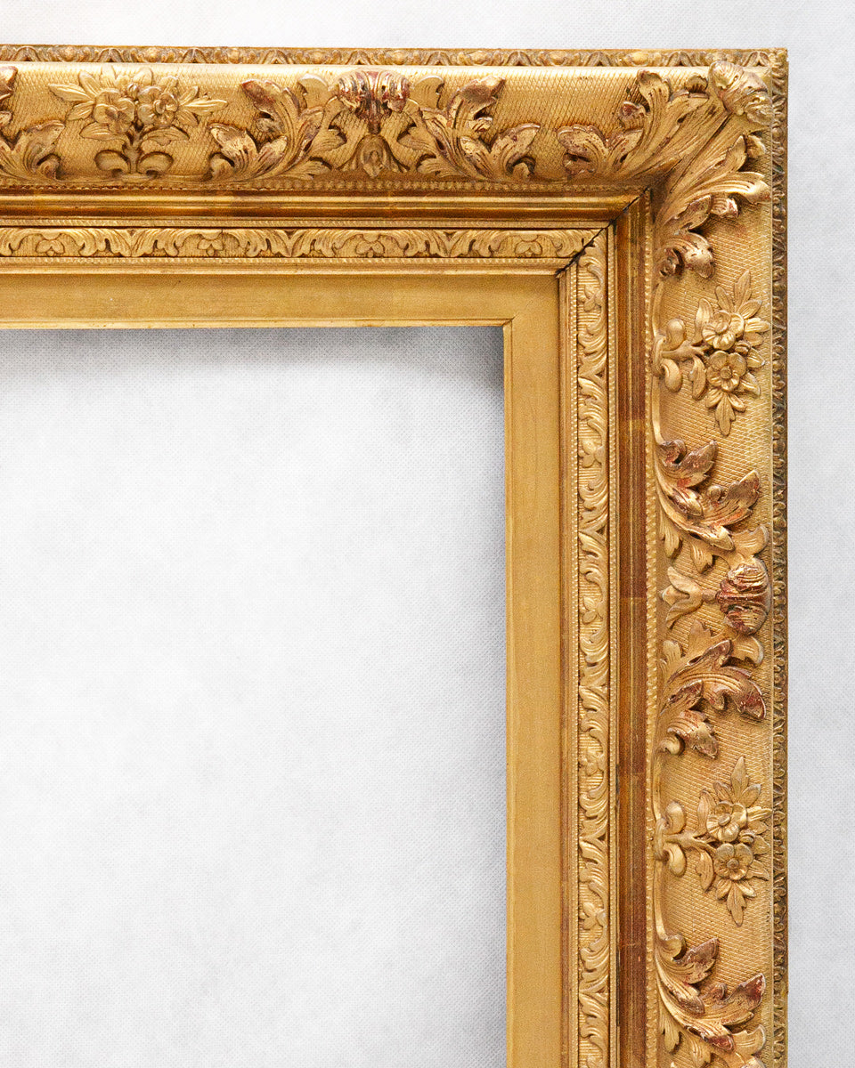Corner of a gold ornate picture frame on a white background