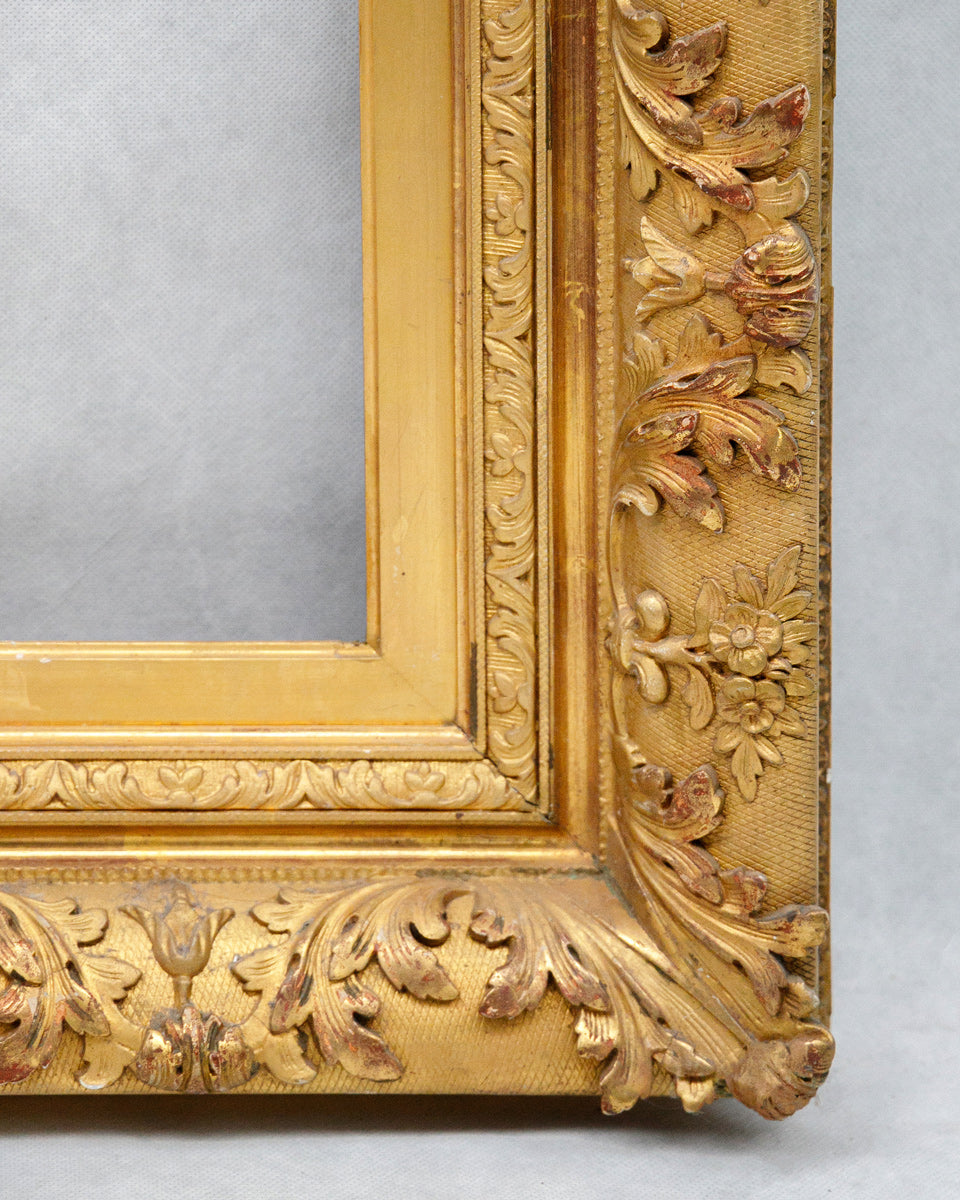Corner of a gold ornate picture frame on a gray background