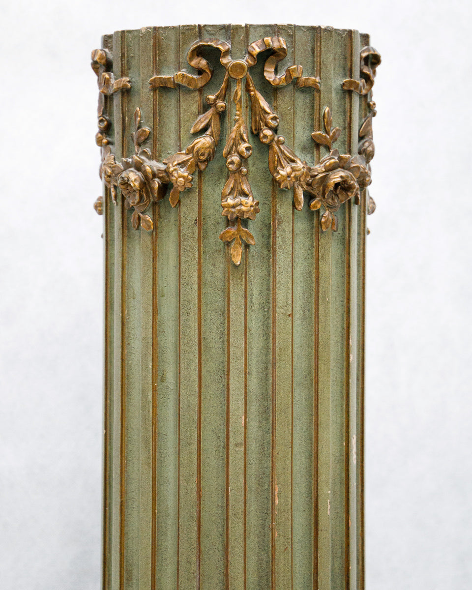 Decorative antique French wooden column with gold leaf detailing on a white background