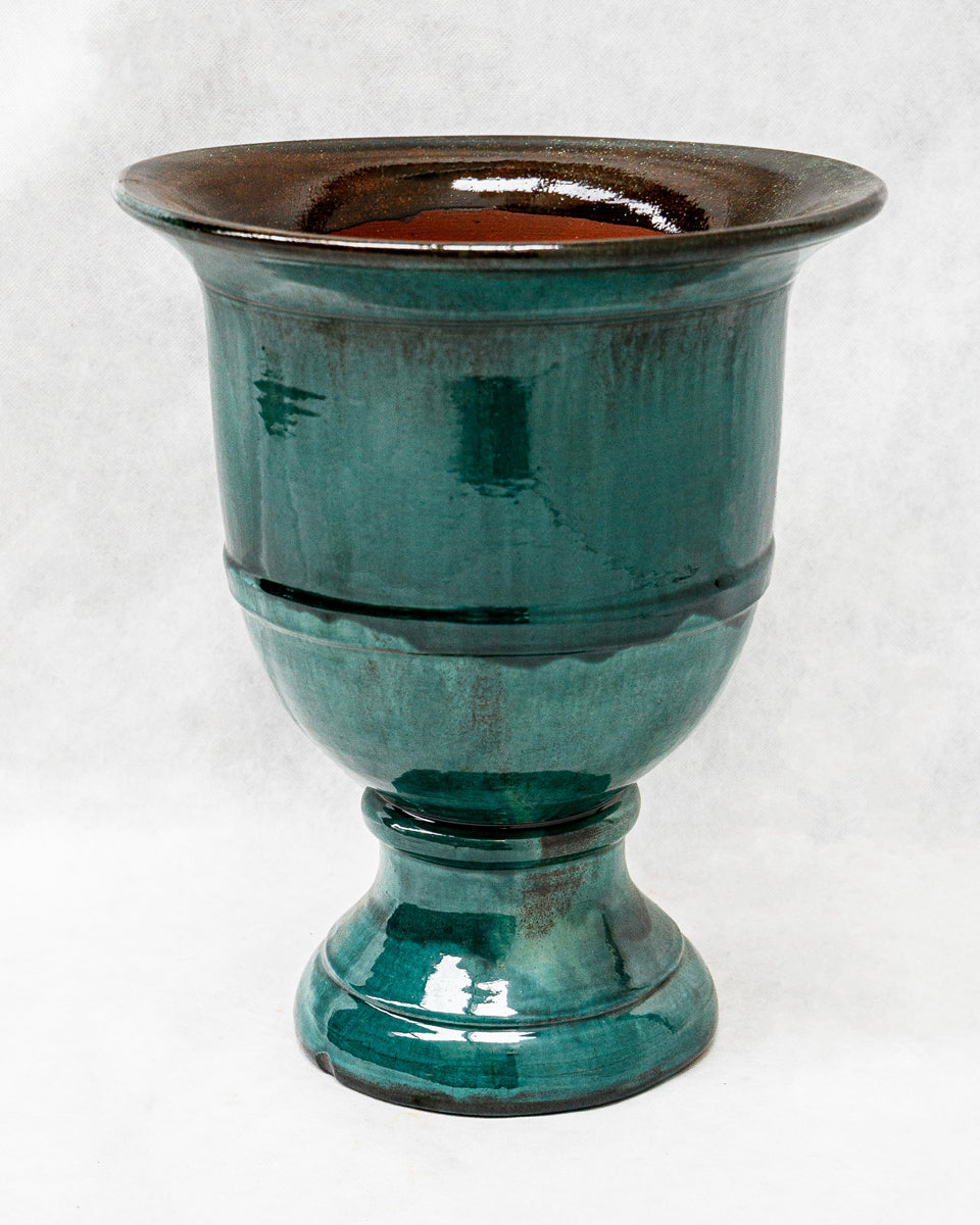 Teal ceramic planter with brown rim on a white background