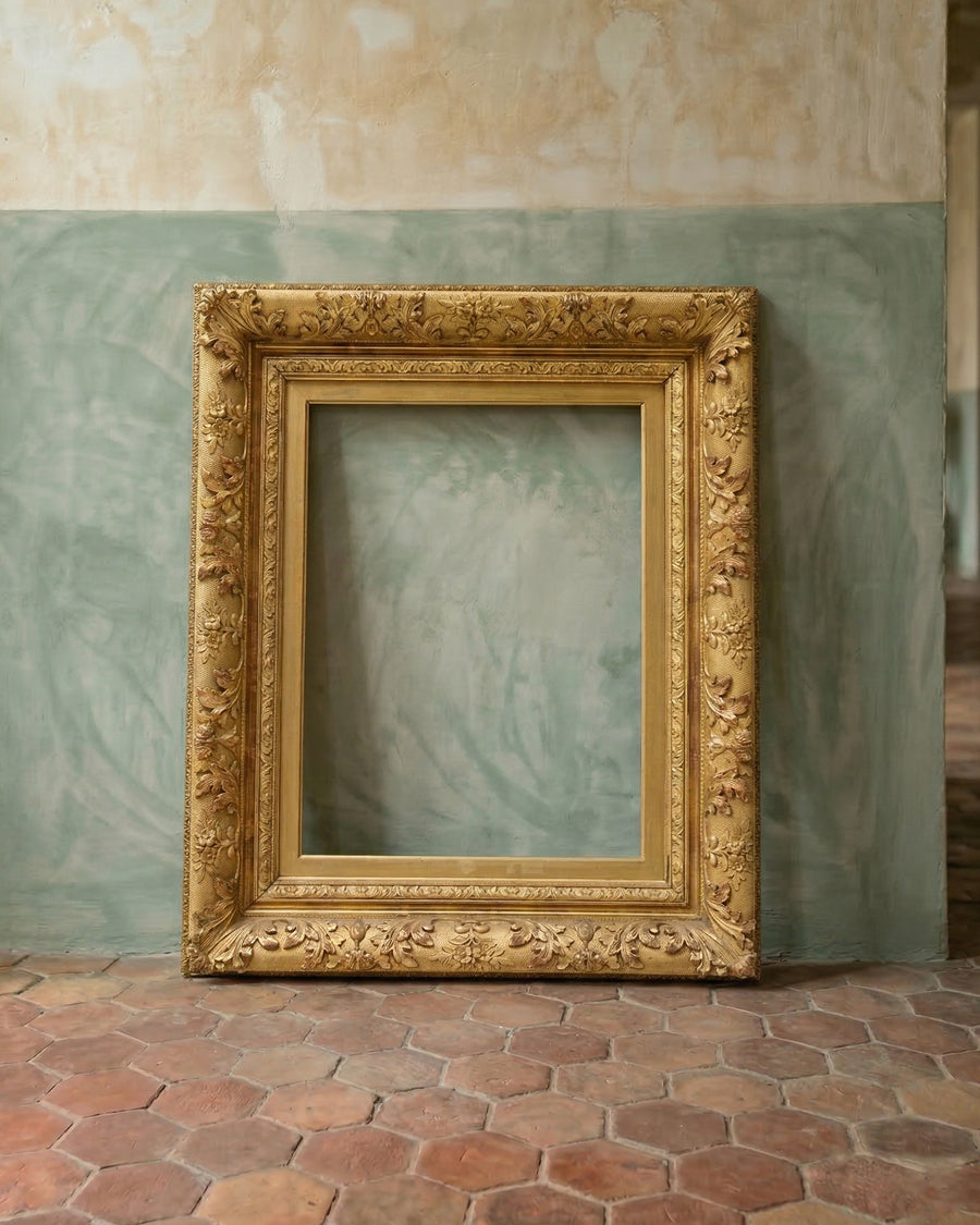 Decorative gold frame on a textured wall with a greenish hue, available via Wildschut Antiques.