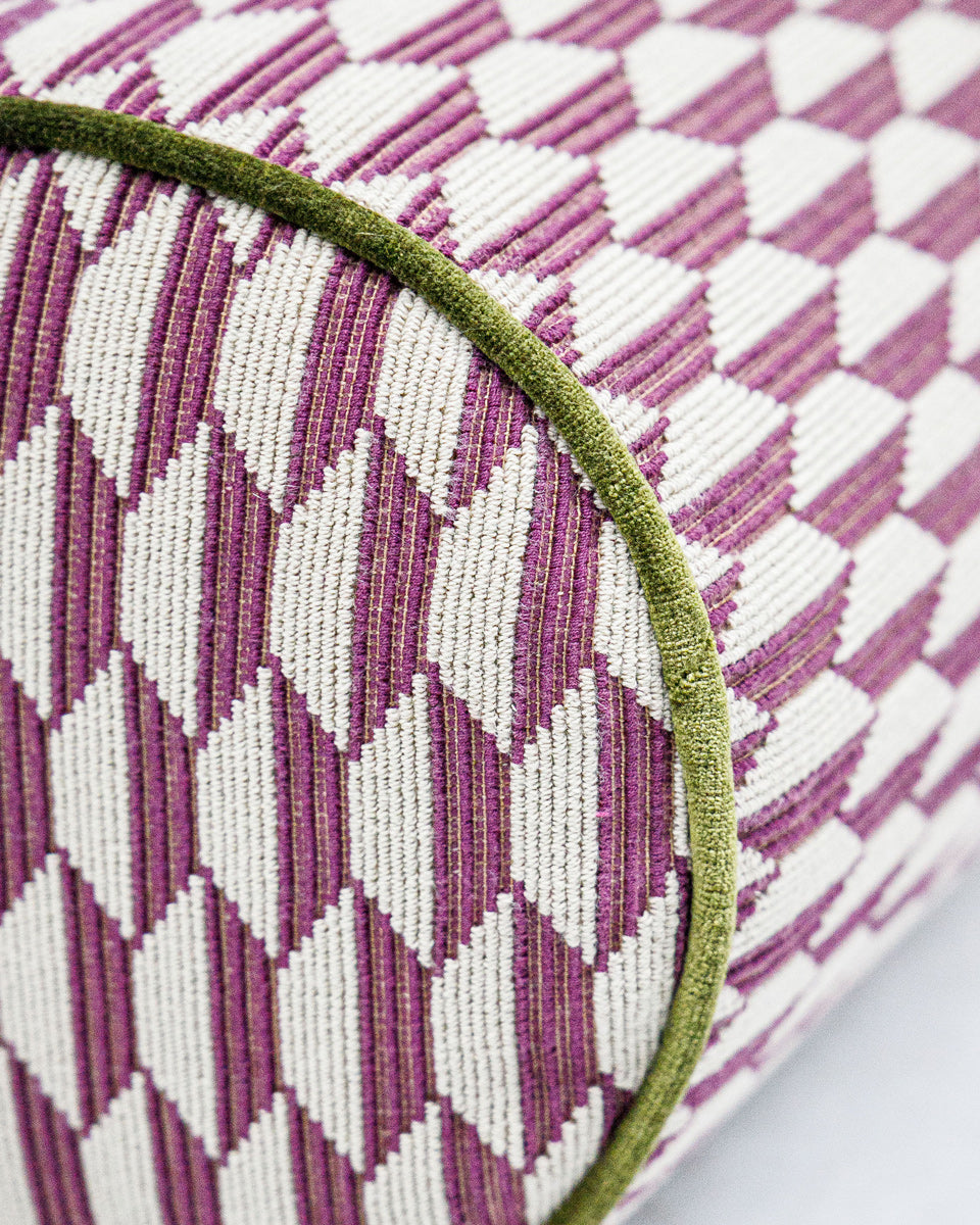 Close-up of a woven pattern with purple and white triangles and a green border