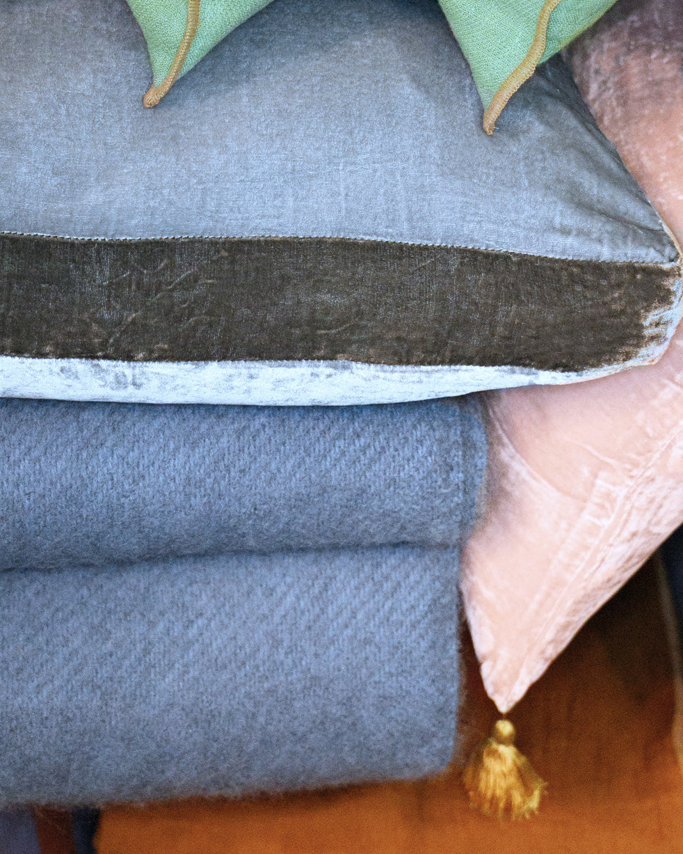 Close-up of a stack of pillows and wool blankets available at Wildschut Antiques.