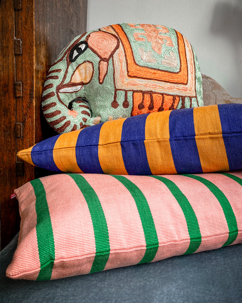 Colorful striped pillows and a pillow in the shape of an elephant available at Wildschut Antiques