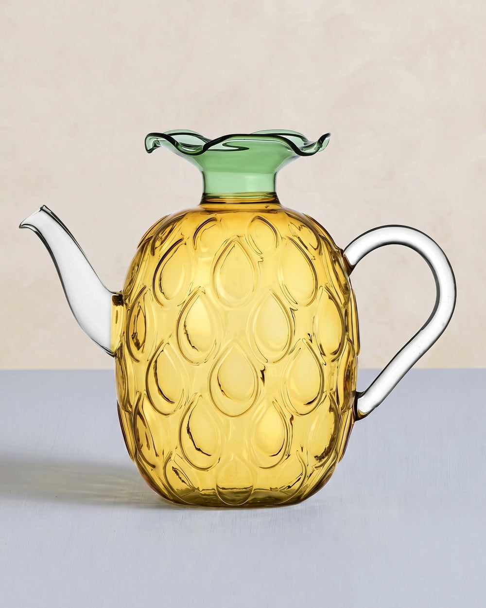 Glass pineapple-shaped teapot with green lid, designed by Ichendorf Milano, displayed on a light background, available at Wildschut Antiques.