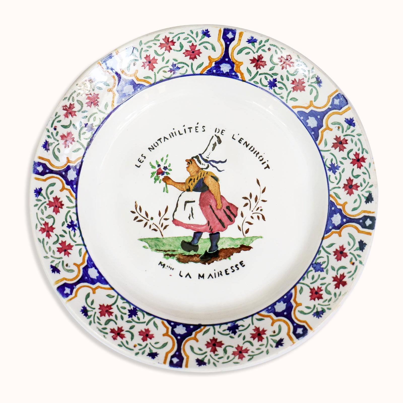 A vintage Gien majolica ceramic plate with a hand-painted depictions of 'Madame La Mairesse' in a floral and colorful design, available at Wildschut Antiques
