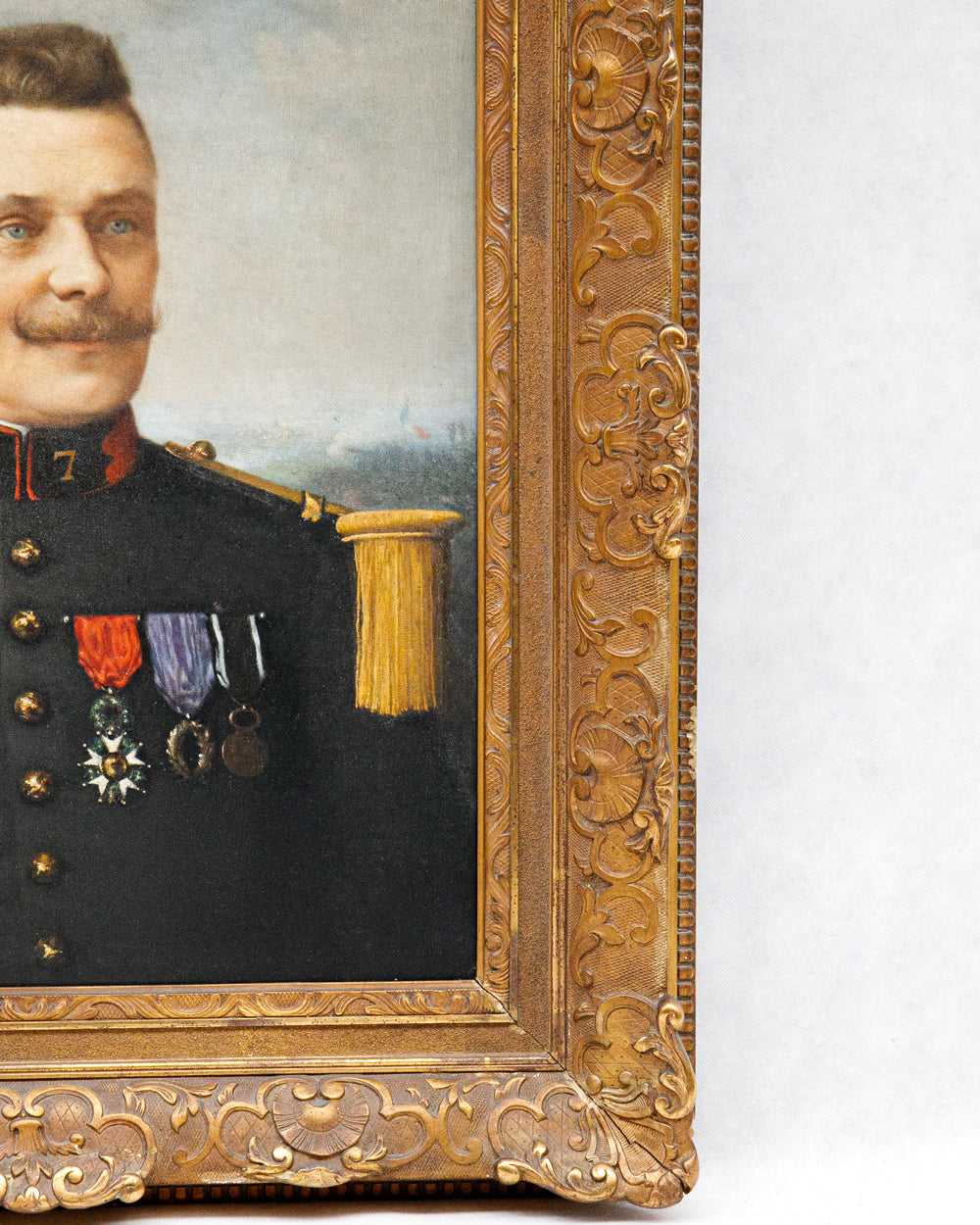 Detail of a portrait of a man in military uniform with medals, framed in an ornate gold frame