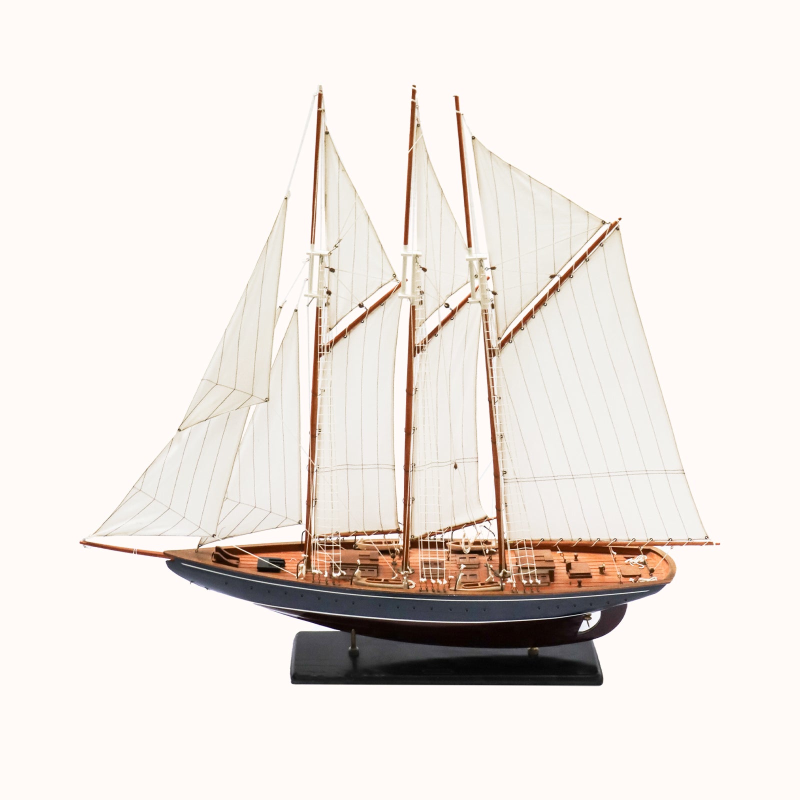 A vintage Marco Polo sail boat model with a predominantly white sail and a brown wooden hull, displayed on a stand, available at Wildschut Antiques
